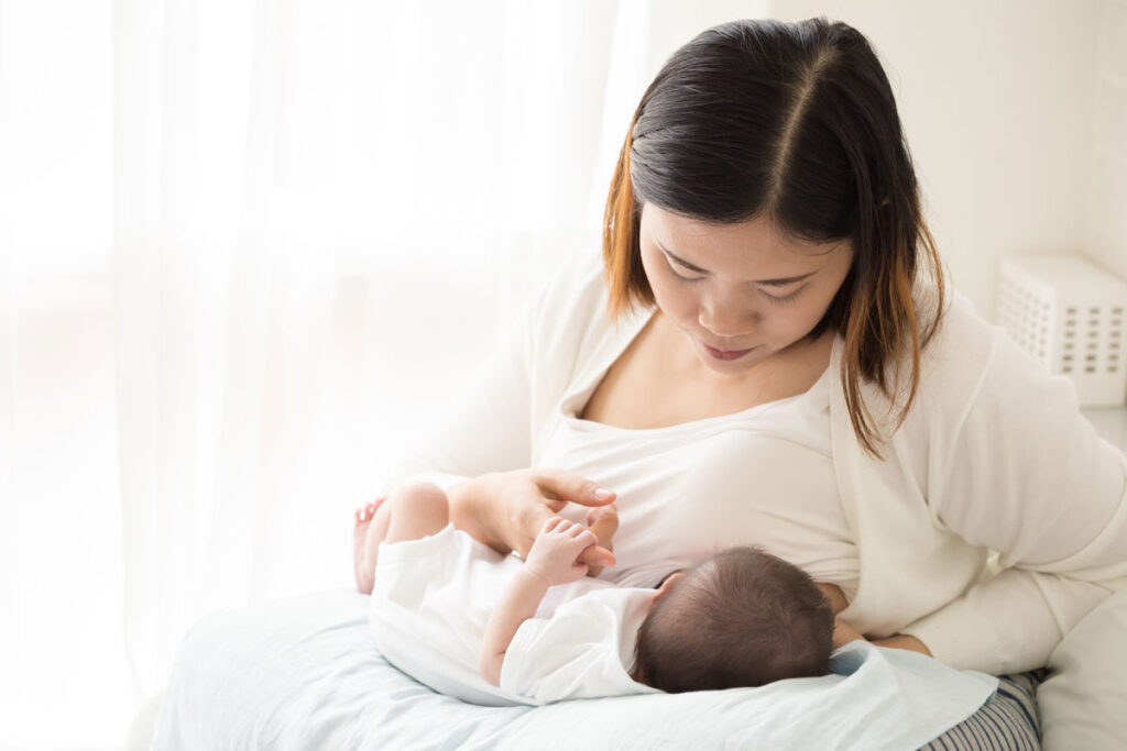 Breastfeeding parent nursing her baby. This baby may not be positioned towards the breast well, which can cause sore nipples.