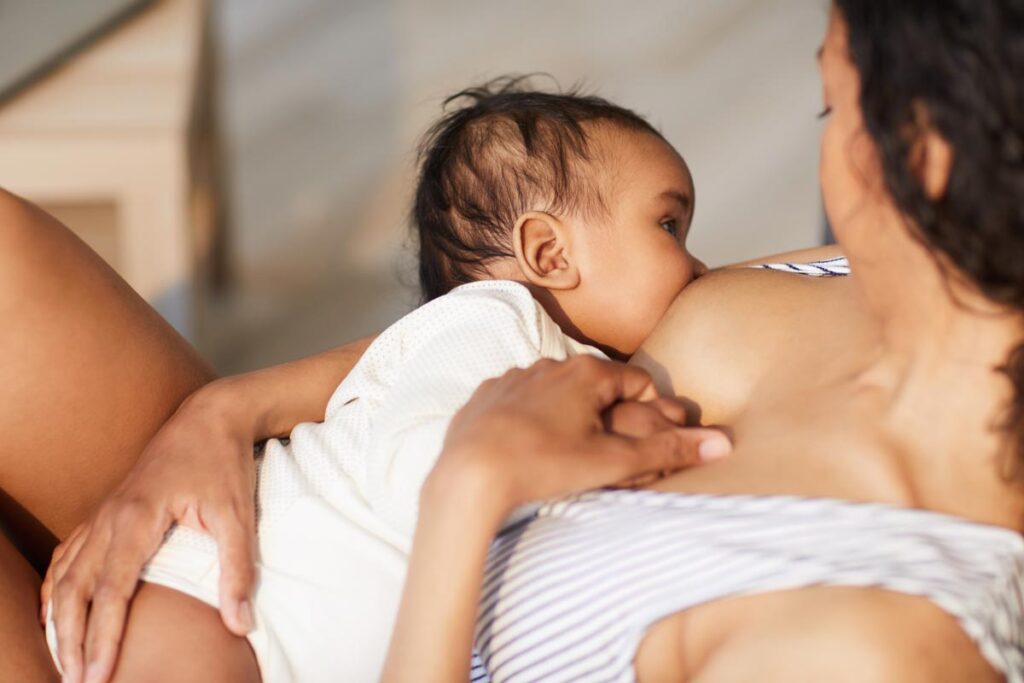 Older baby in a laid-back breastfeeding position with mom