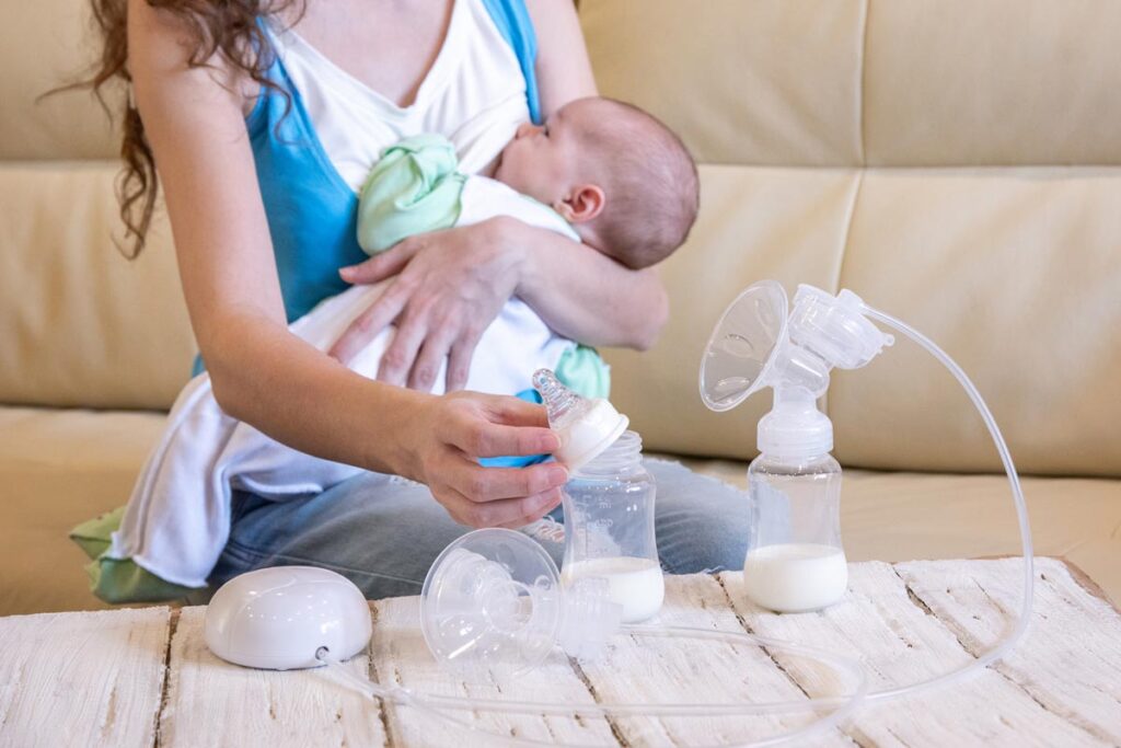A breastfeeding parent triple feeding her baby