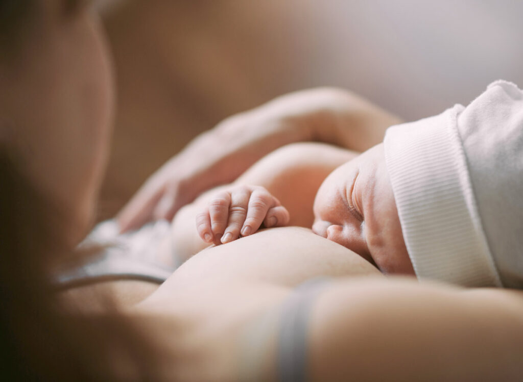 Newborn on mother's chest breastfeeding