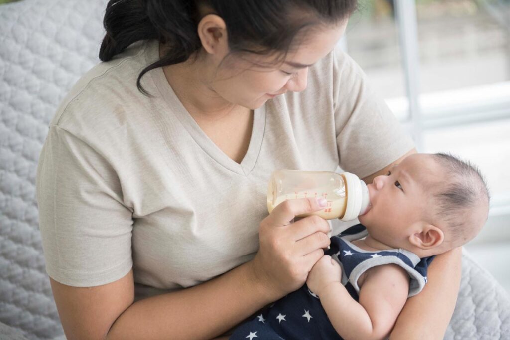 Breastfeeding mother pace feeding a bottle